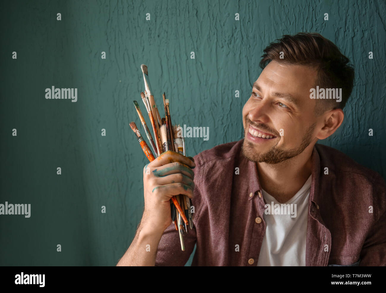 Man Using Art Tools Male artist with paint tools near color wall Stock Photo - Alamy