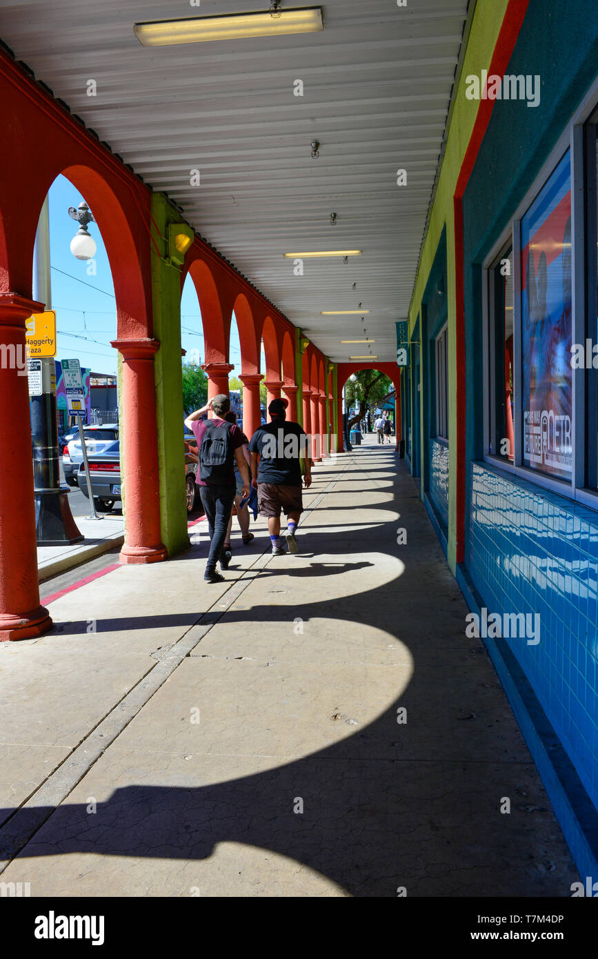 People stroll along the colorful Spanish style portal walkway in front