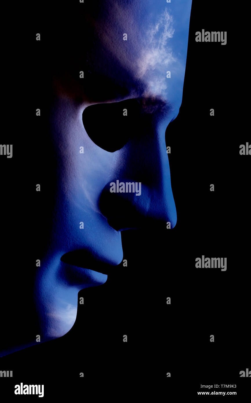 Robot face mask side view close up with textured skin and blank eyes. Black background and space for text. Artificial intelligence concept in a human  Stock Photo
