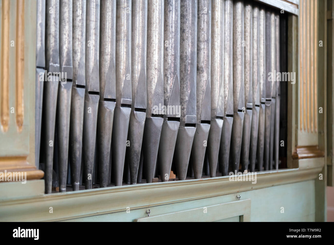 Old, silver organ pipes in a church used for playing sacred music. Many air pipes, sound tubes in the cathedral Stock Photo