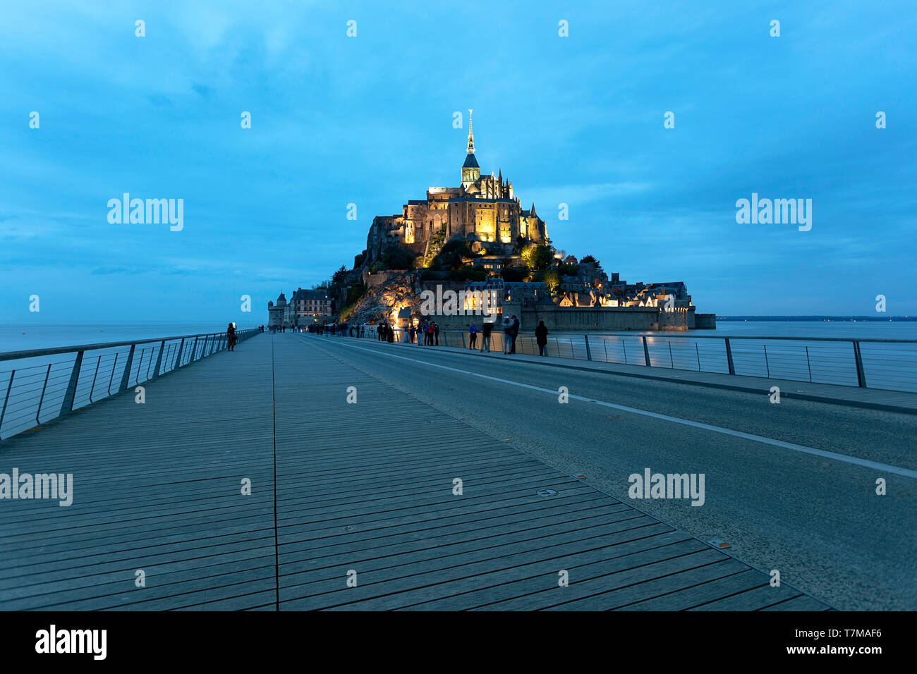 Blurred crowds on the bridge at Mont saint Michel at twilight, Normandy, France Stock Photo