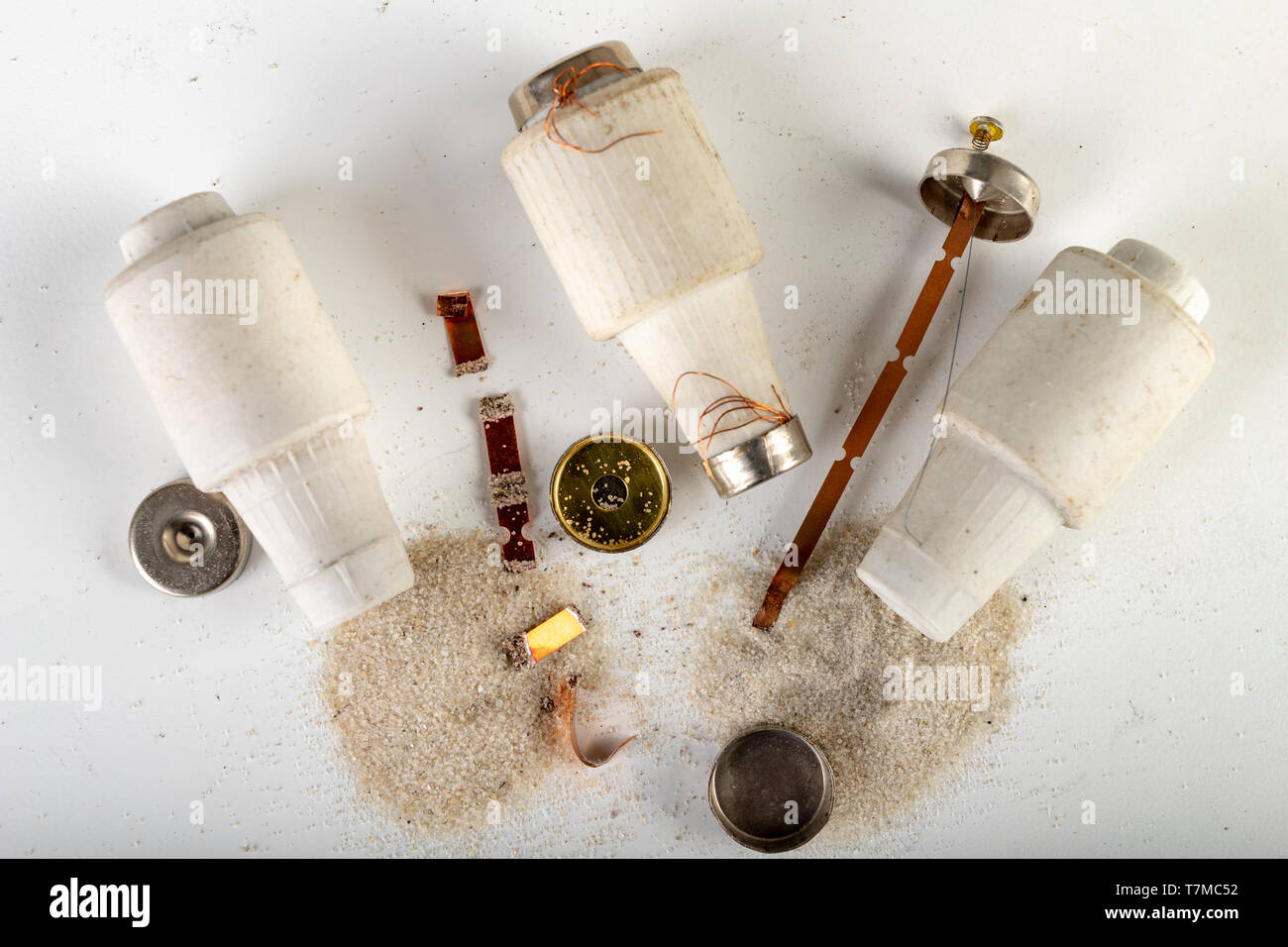 Old ceramic electric fuse. Blown and badly repaired security for energy