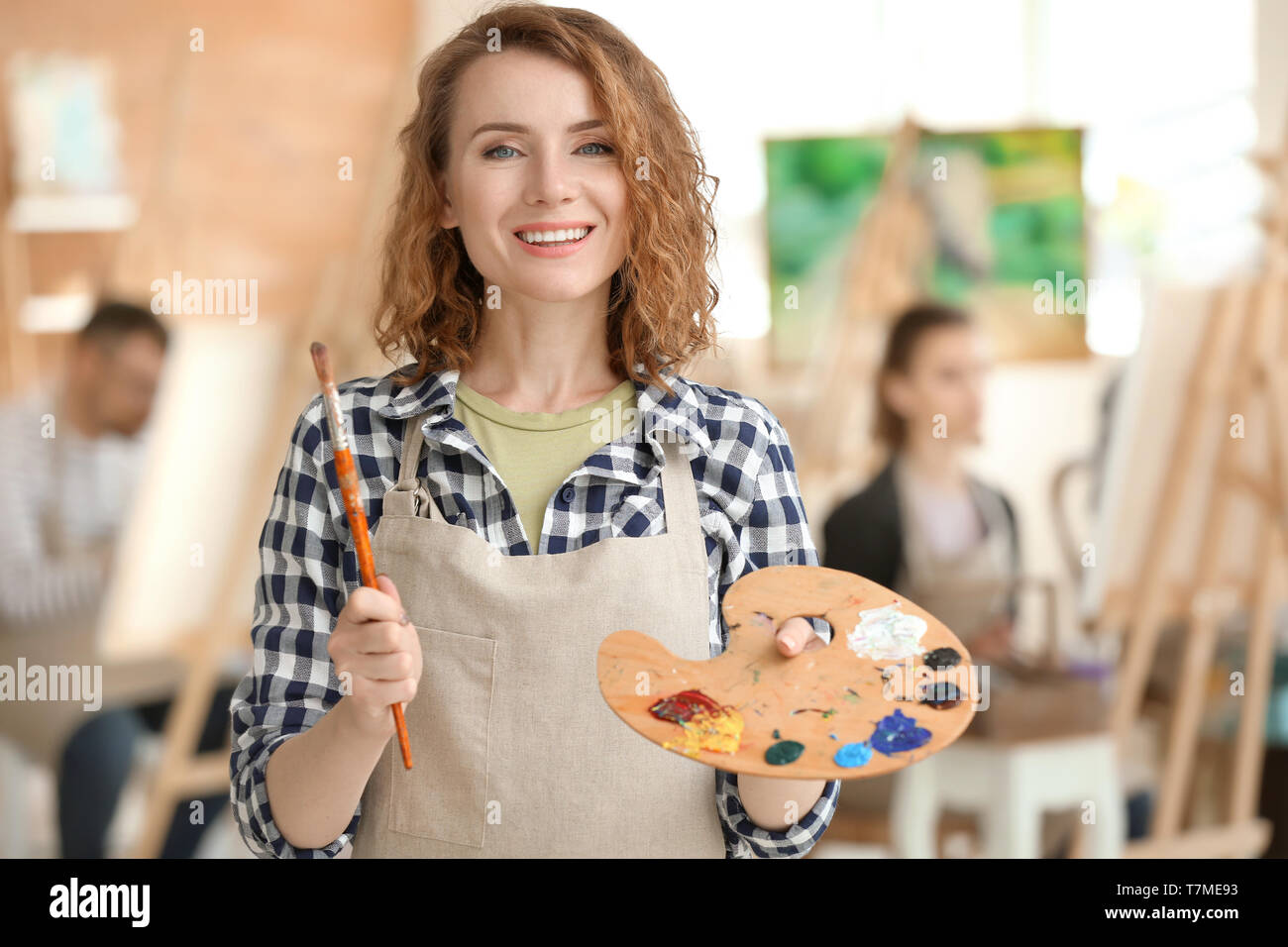 Female artist with brush and paint palette in workshop Stock Photo - Alamy