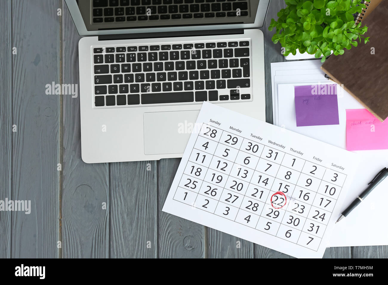 Calendar with notes and laptop on wooden background Stock Photo - Alamy