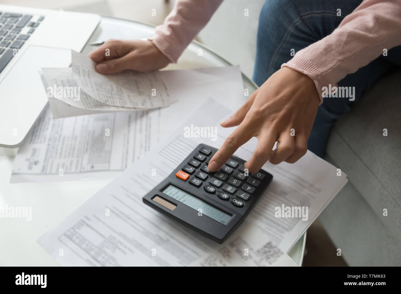 Close up woman hands holding receipt calculating company expenses Stock Photo