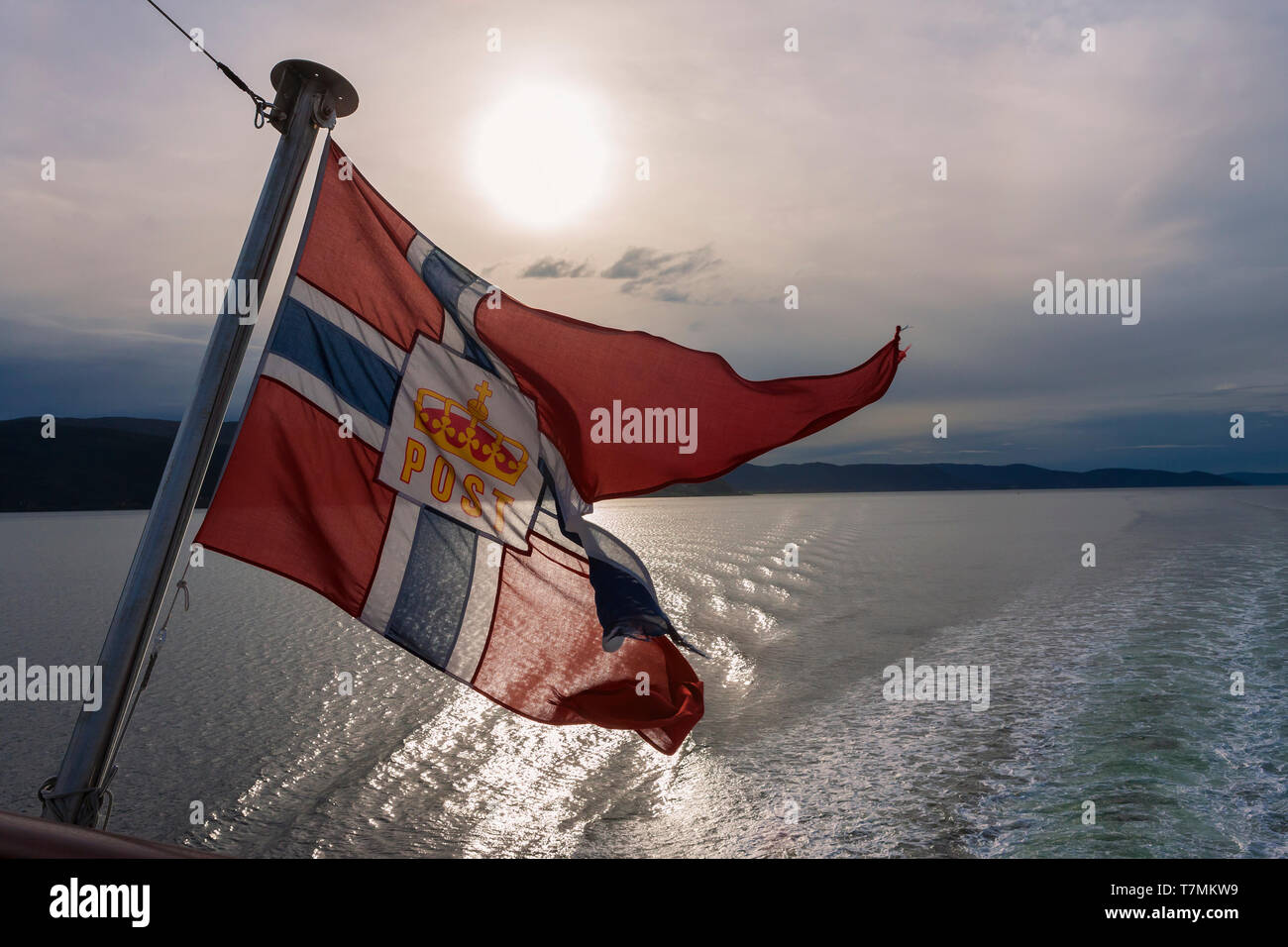 Flag of Norwegian Postal Services, as flown from the stern of Hurtigruten ship 'MS Spitsbergen', Trondheimsfjorden, Trøndelag, Norway Stock Photo