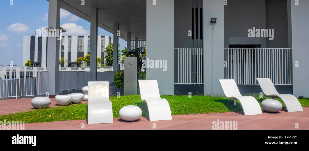 Outdoor sunlounger furniture on the 50th floor sky garden viewing platform at Pinnacle@Duxton apartment complex Singapore. Stock Photo