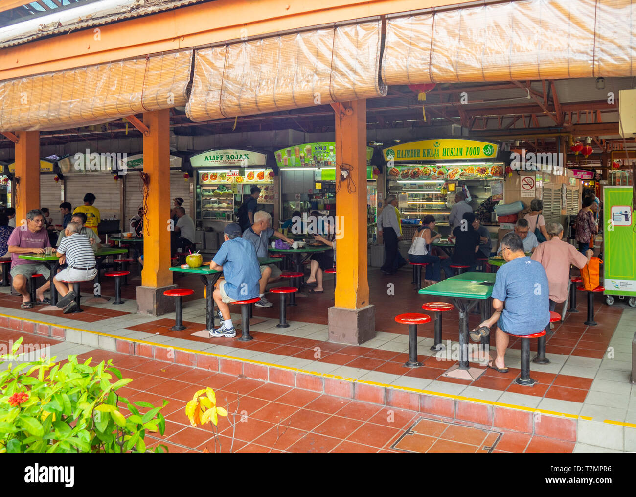 People, locals sitting down eating lunch at Maxwell Food Centre a