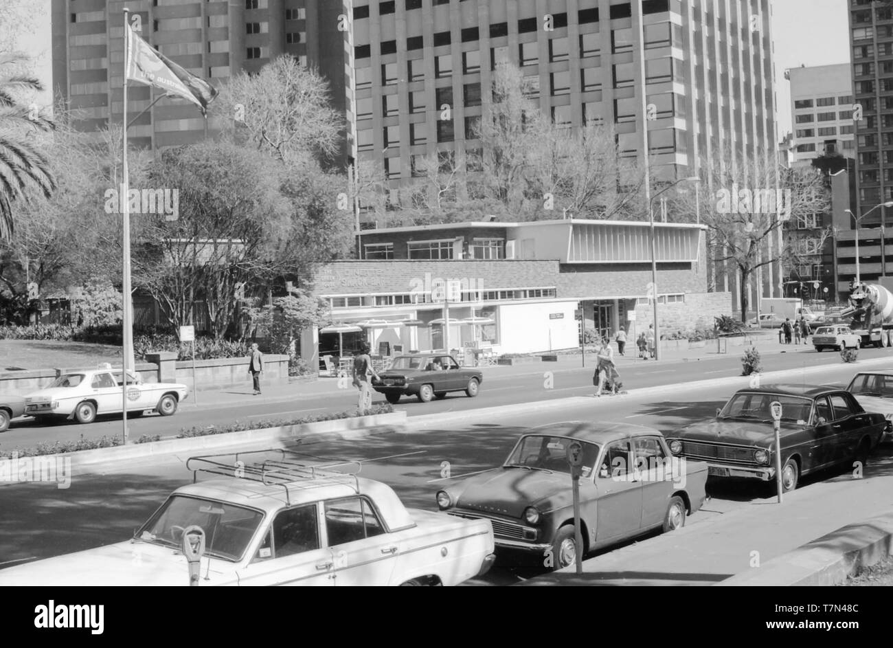 1977 Sydney Australia: Looking south west across Park St that divides the north and south part of  Hyde Park to the 1955 built Green House Dinette and Snack Bar and to its right the Family Centre. The building was demolished and the area grassed over in 2000. Stock Photo