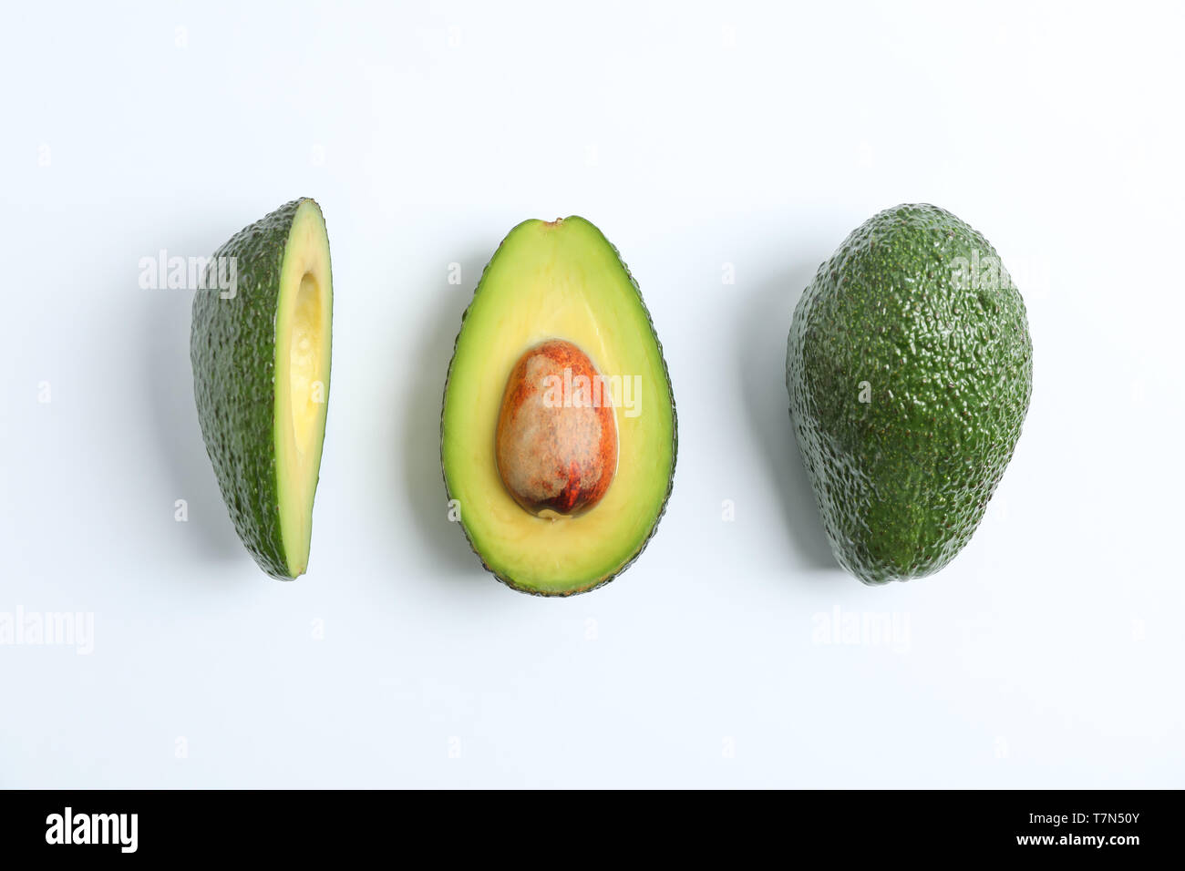 Flat lay composition with ripe avocados on white background, space for ...