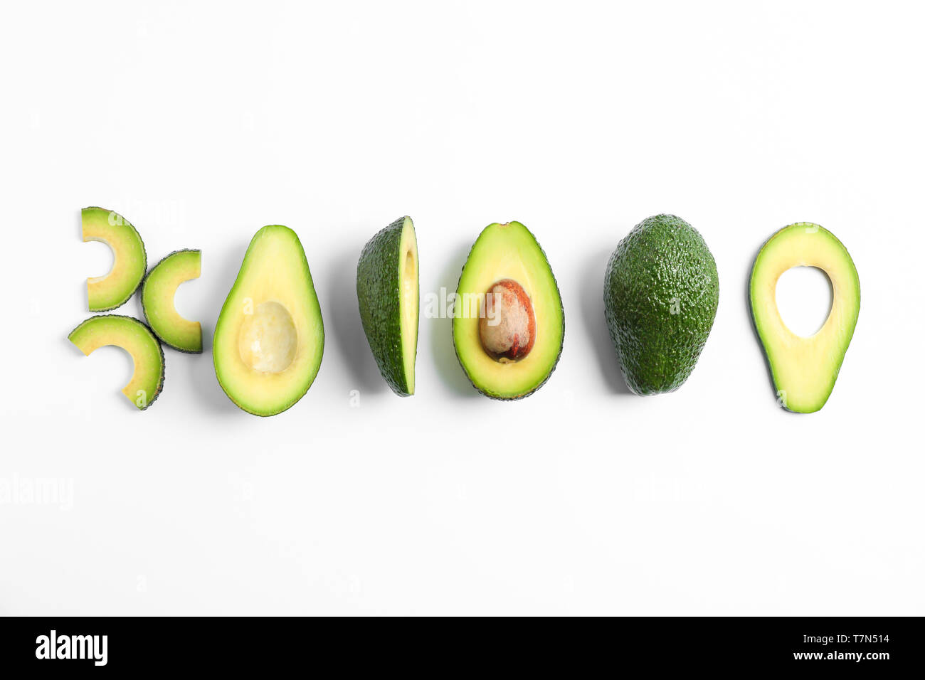 Flat lay composition with ripe cut avocados on white background, space ...