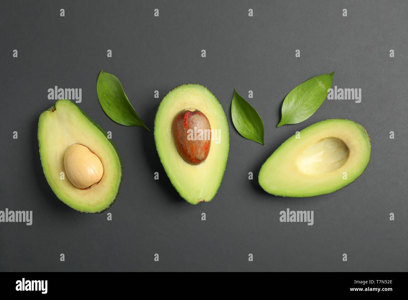 Flat lay composition with ripe avocados on black background, space for ...