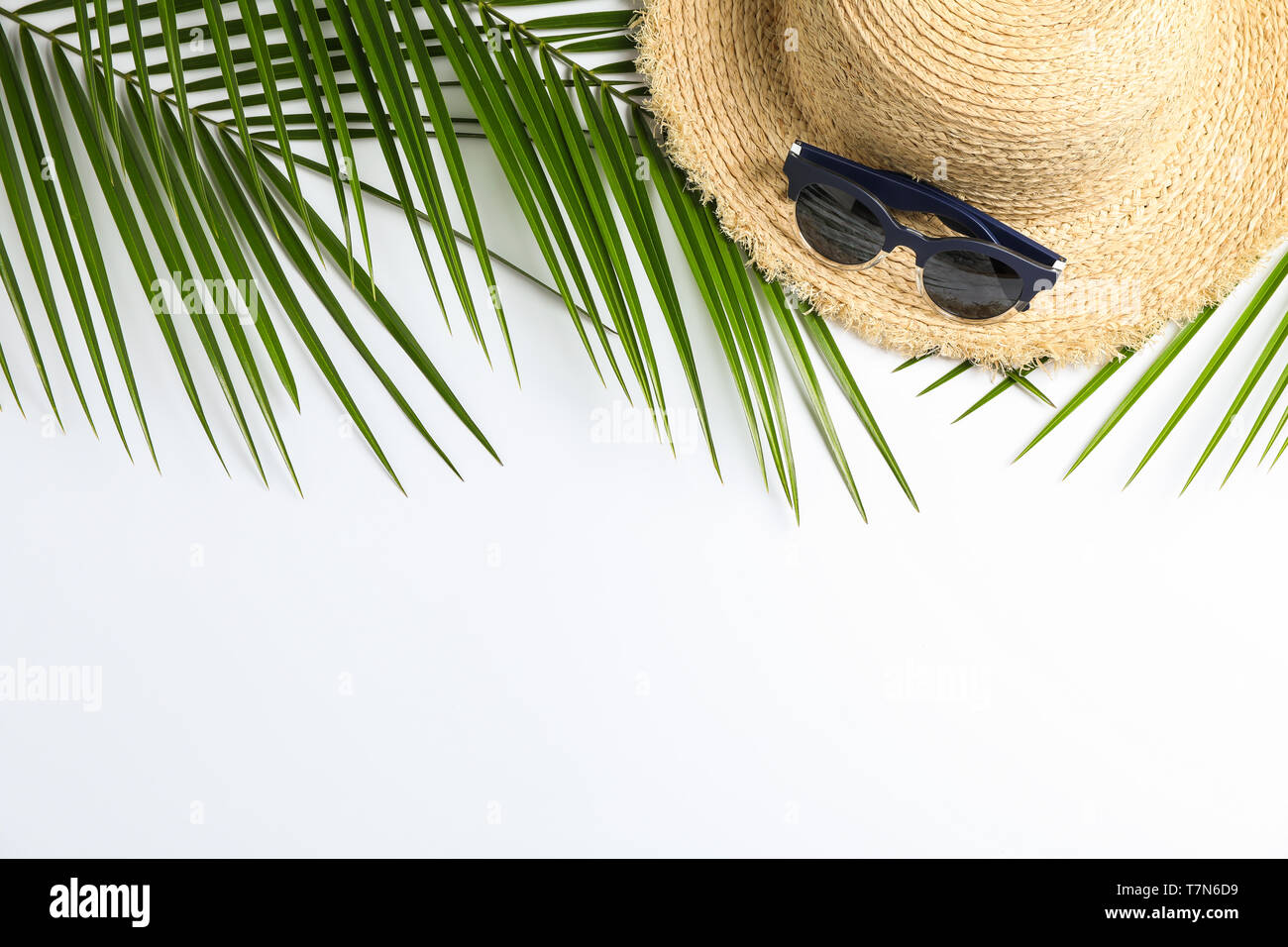 Composition with straw hat, sunglasses and palm leaves on white ...
