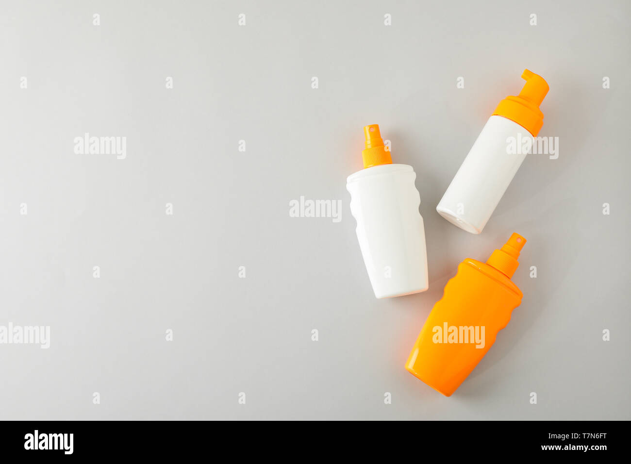 Flat lay composition with sunscreen sprays on grey background. Space for text, top view Stock Photo