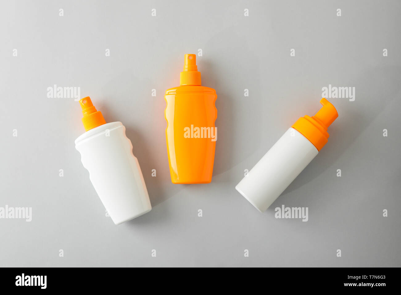 Flat lay composition with sunscreen sprays on grey background. Space for text, top view Stock Photo