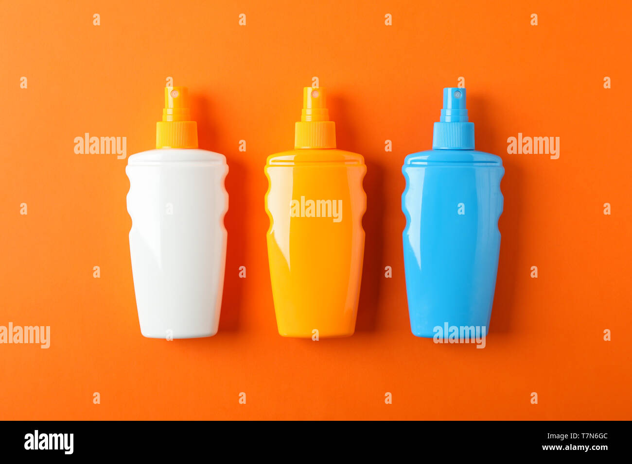 Flat lay composition with sunscreen sprays on color background. Space for text Stock Photo