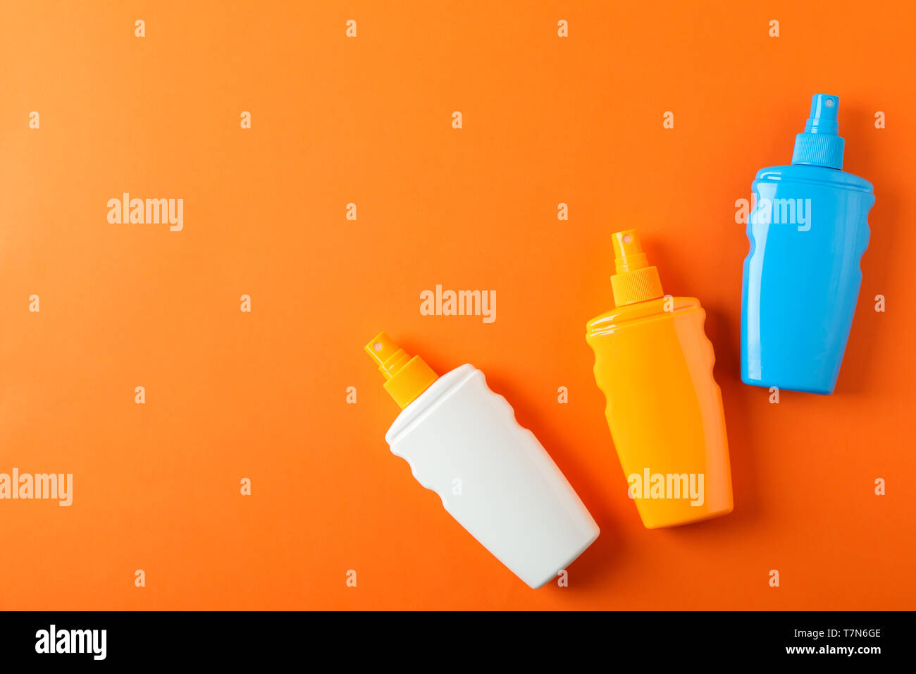 Flat lay composition with sunscreen sprays on color background. Space for text Stock Photo