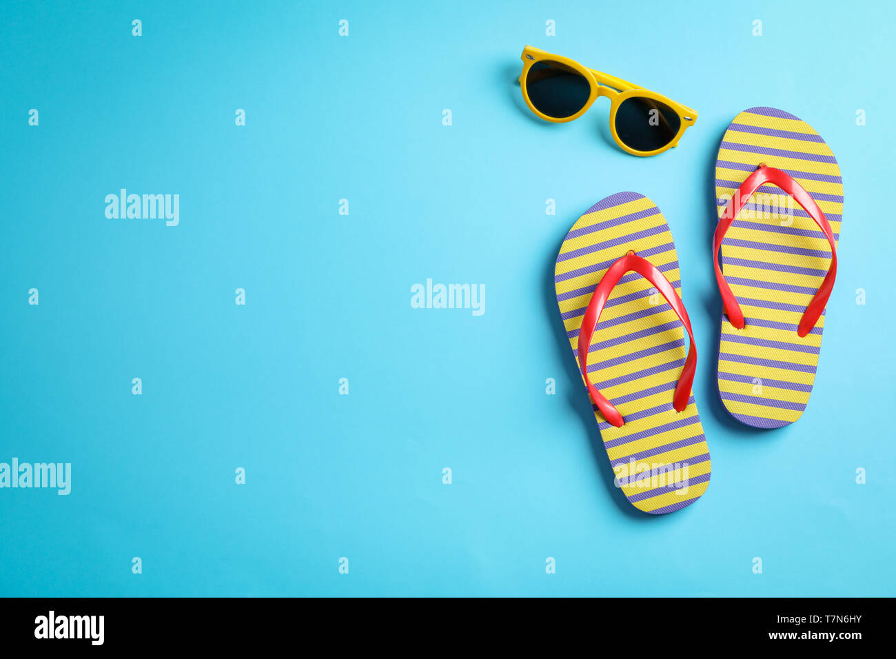 Sunglasses and flip flops on color background, space for text Stock ...