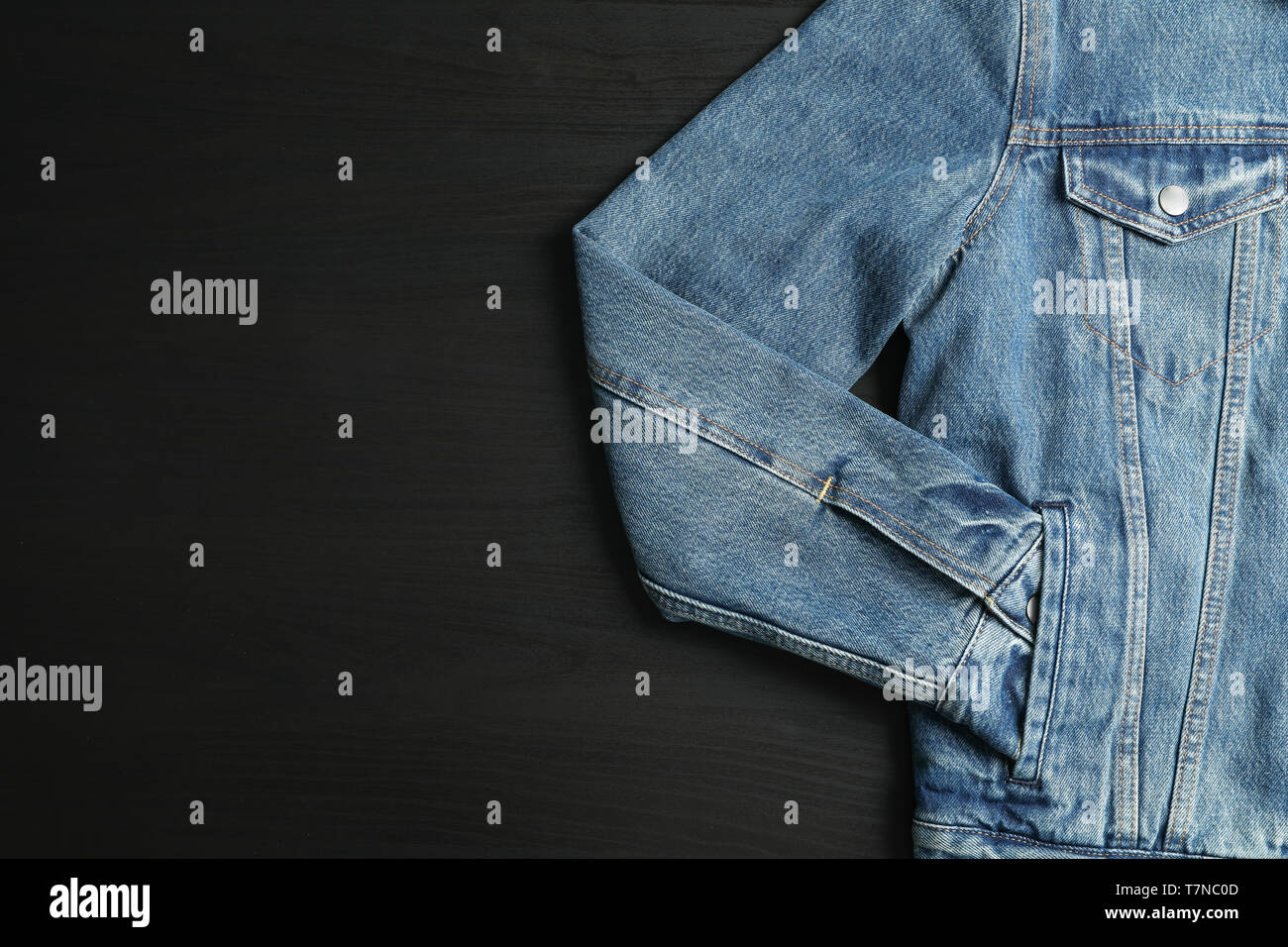 Denim jacket on black background, space for text Stock Photo