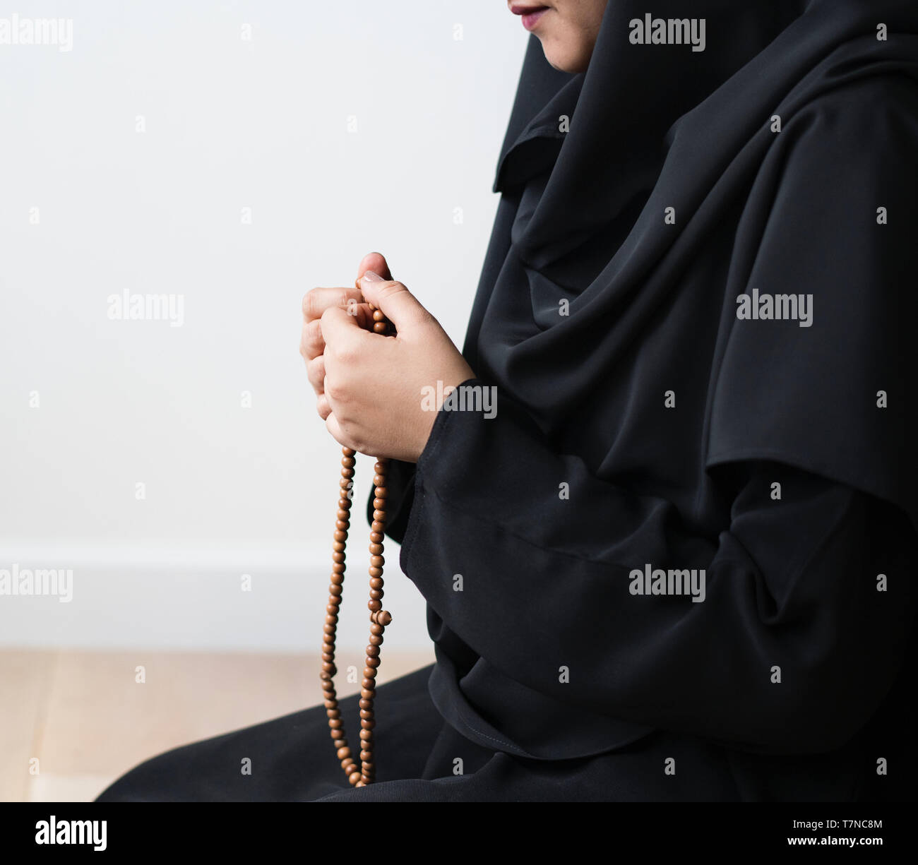 Muslim woman in a black dress holding wooden prayer beads Stock Photo ...