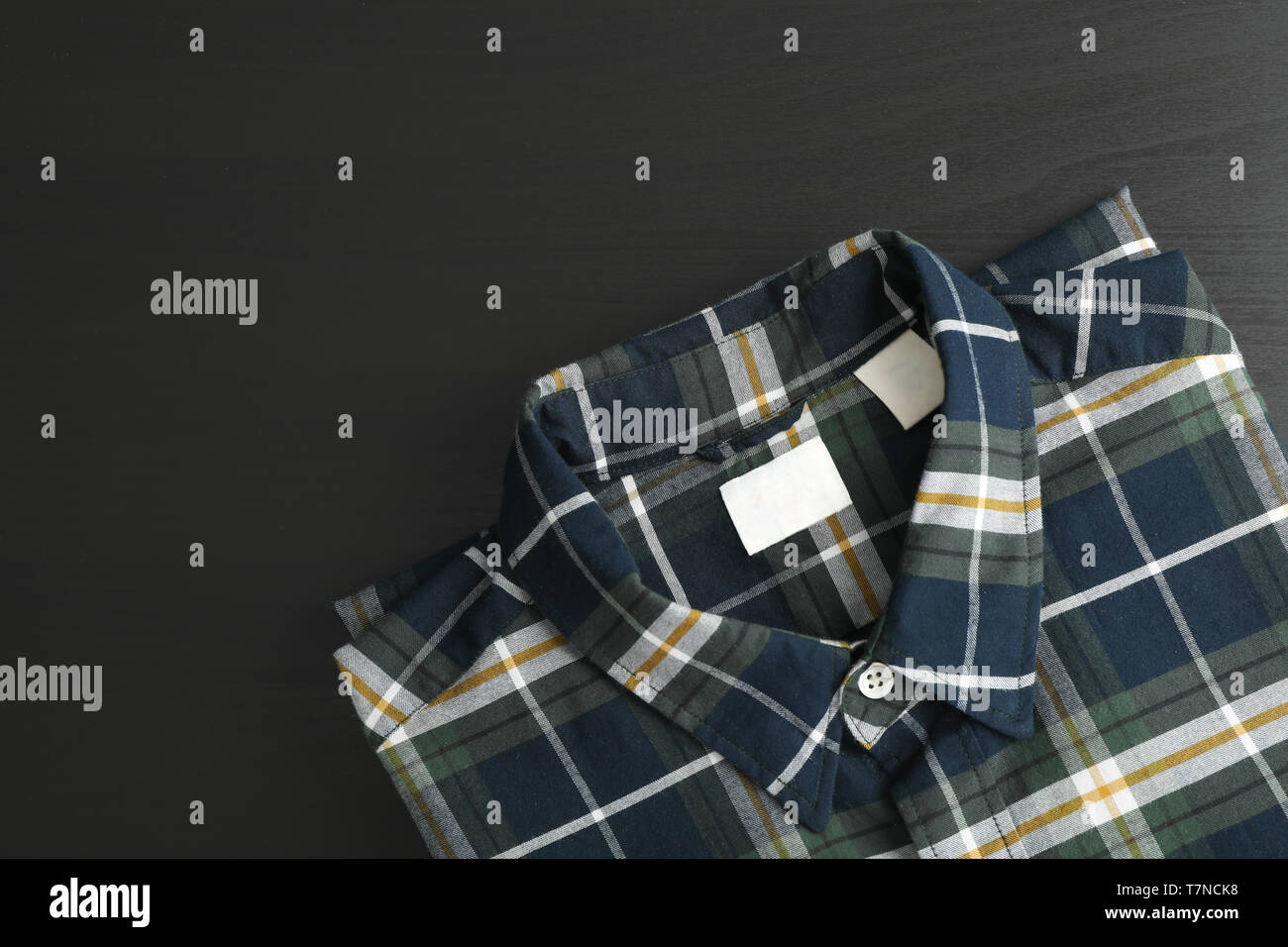 Folded checkered shirt on black table, space for text Stock Photo