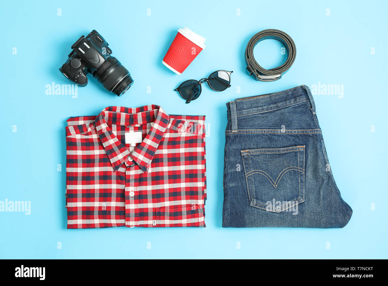 Flat lay composition with shirt, jeans, glasses and camera on color background Stock Photo