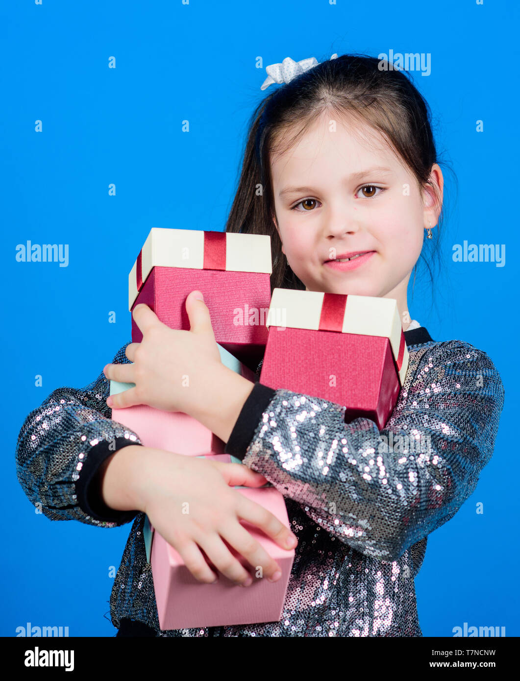 Child carry lot gift boxes. Kids fashion. Surprise gift box. Birthday wish list. Special happens every day. Shop for what you want. Girl with gift boxes blue background. Black friday. Shopping day. Stock Photo