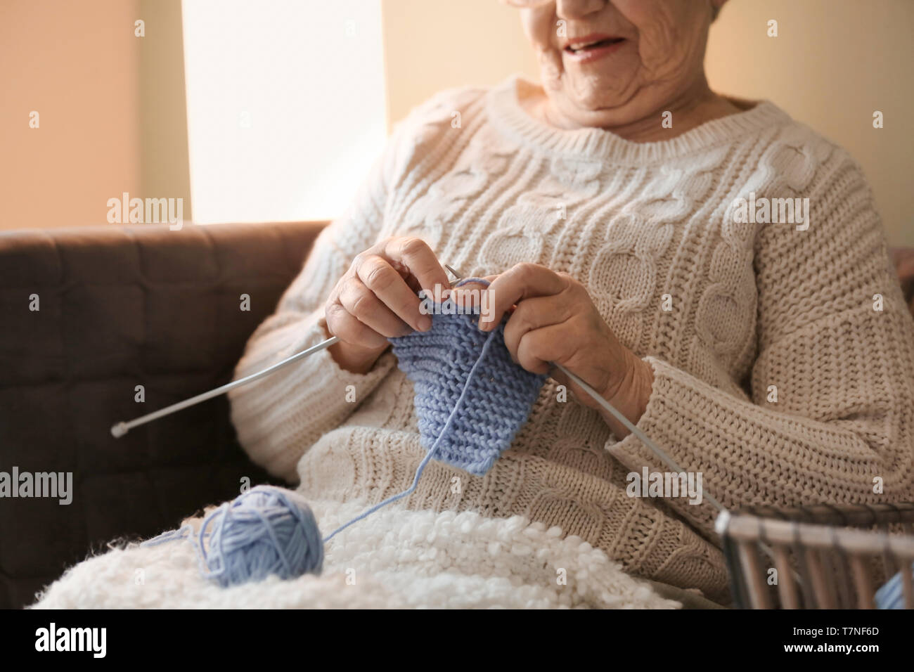 Senior woman knitting warm sock at home Stock Photo