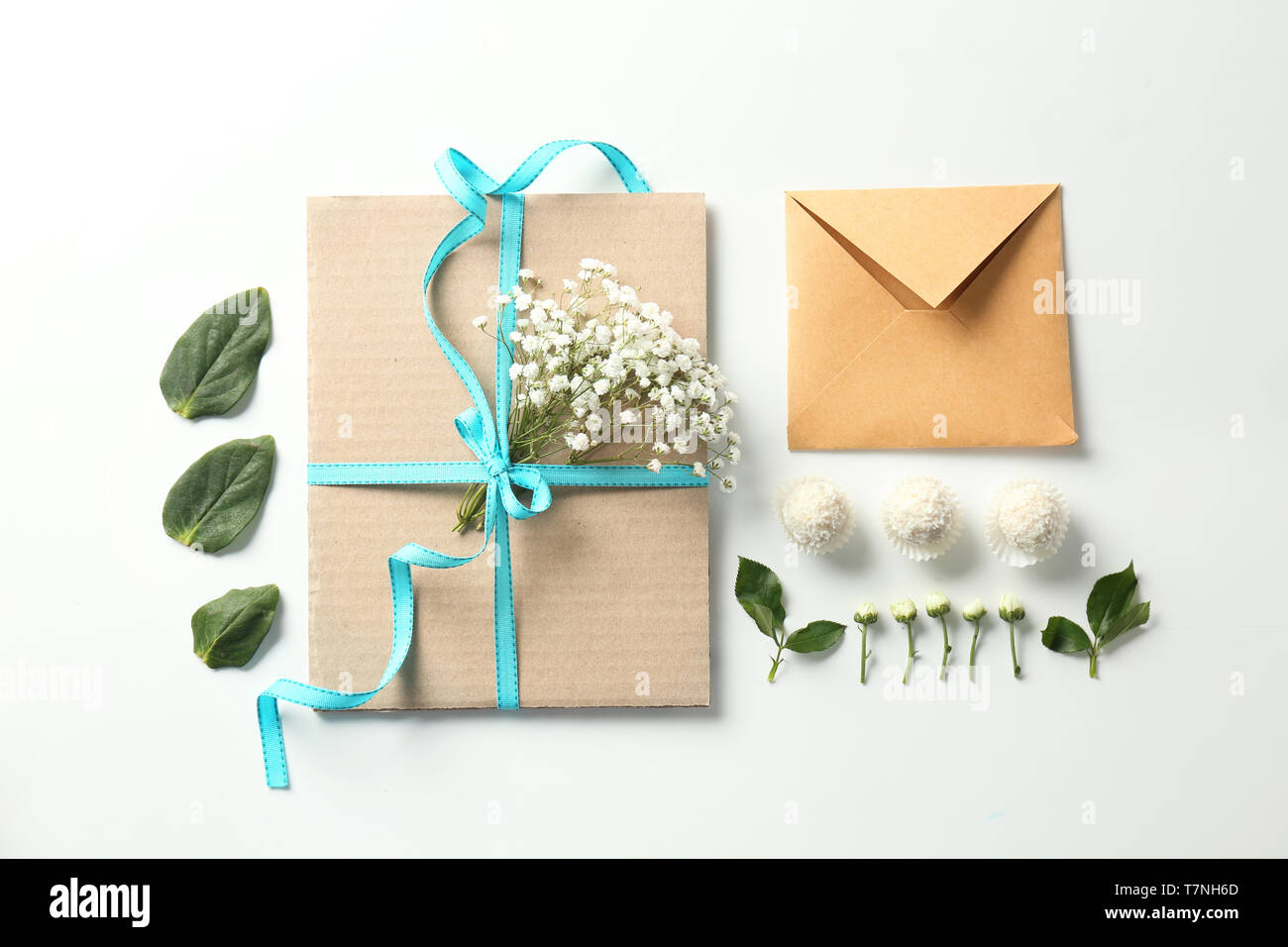 Flat lay composition with flowers and envelopes on white background Stock Photo