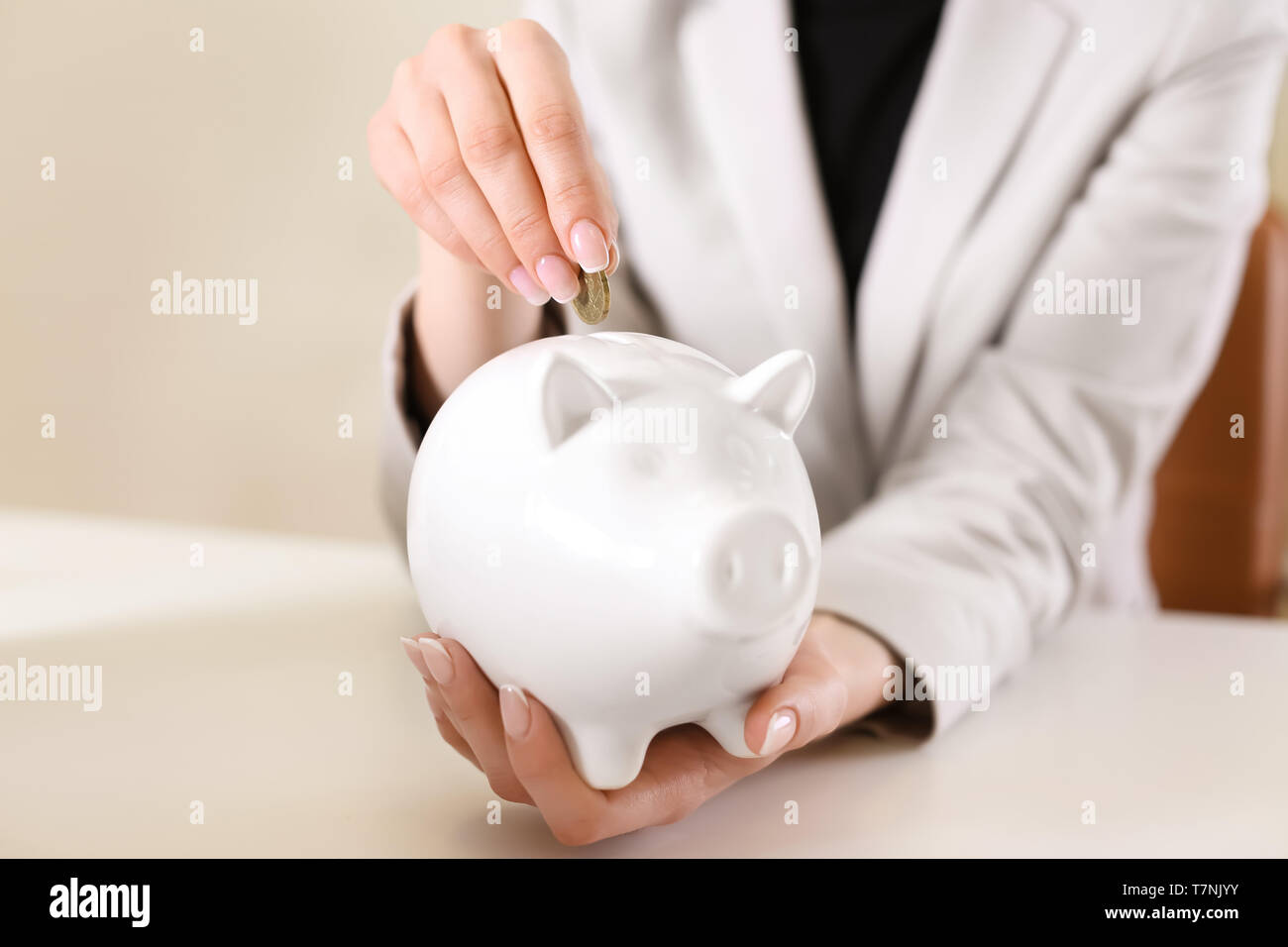 Woman putting coin into piggy bank. Savings concept Stock Photo - Alamy