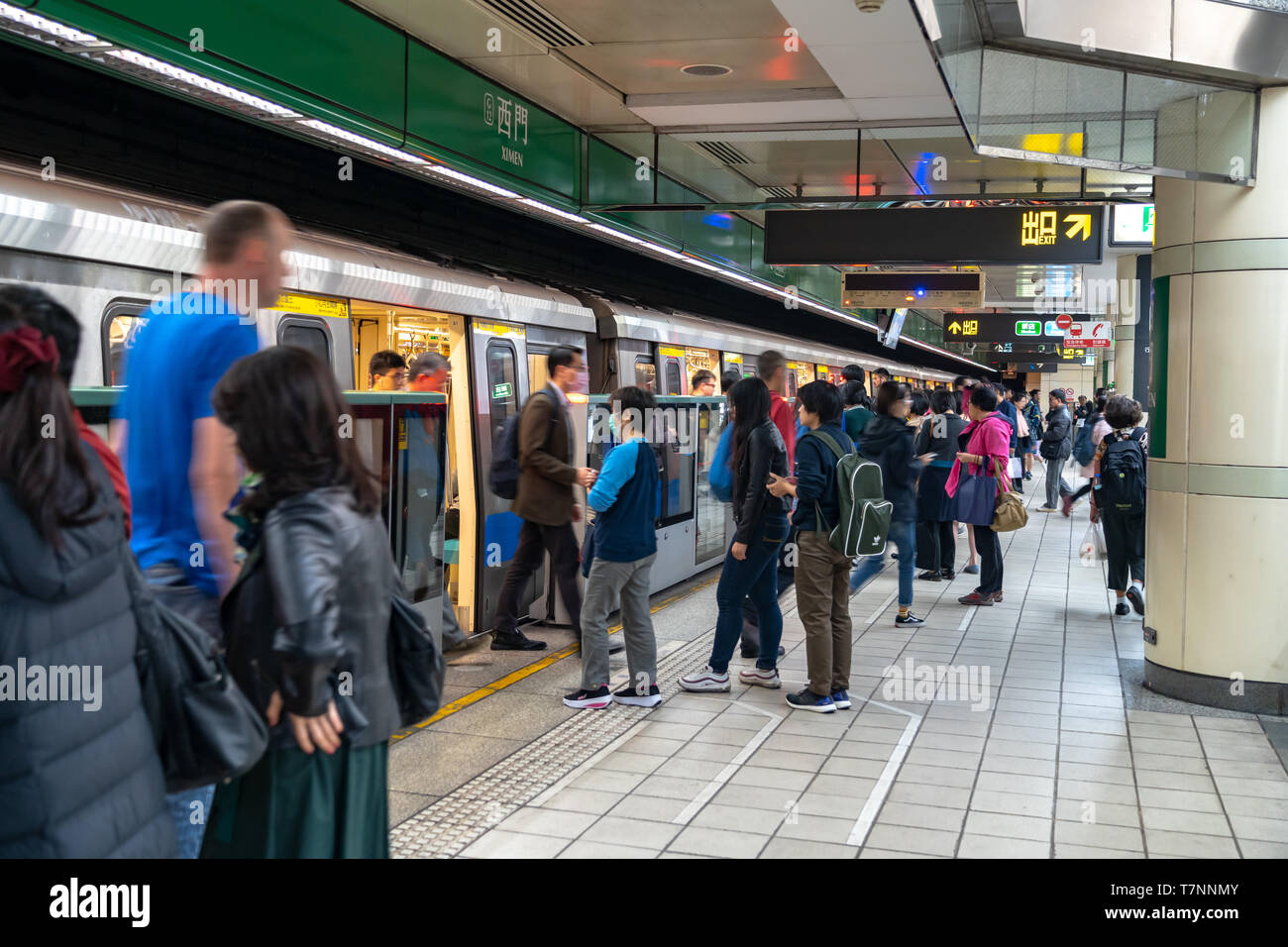 Taipei metro station hall and platform. Subway passengers walk through ...