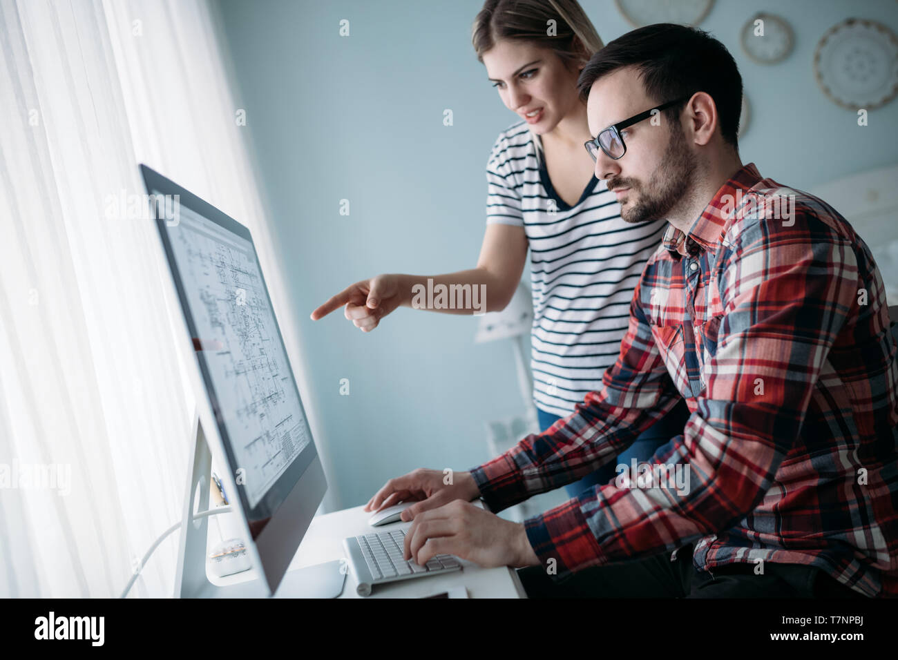 Young attractive designers working on project together Stock Photo