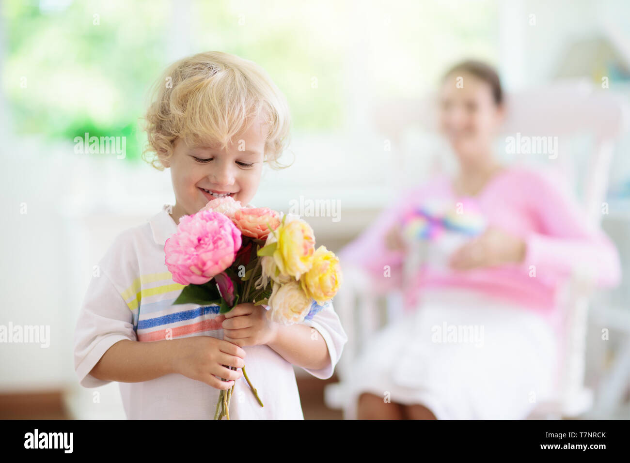 Happy Mother S Day Child With Present And Flowers For Mom Little Boy Holding Wrapped Gift And Flower Bouquet For Mother Family Celebrating Spring H Stock Photo Alamy
