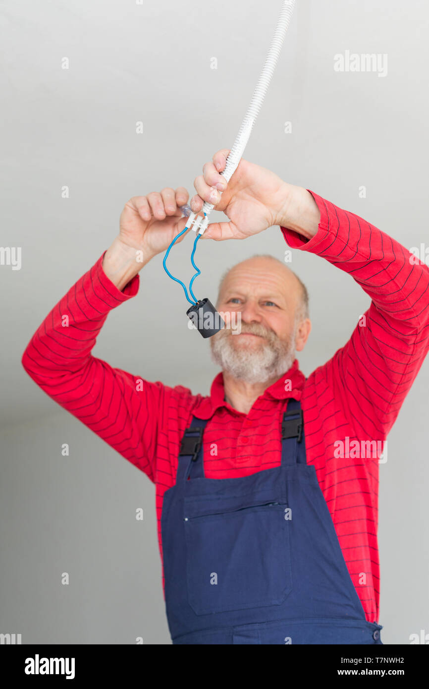 Close up picture of a senior electrician working in a new apartment - electric installation concept Stock Photo