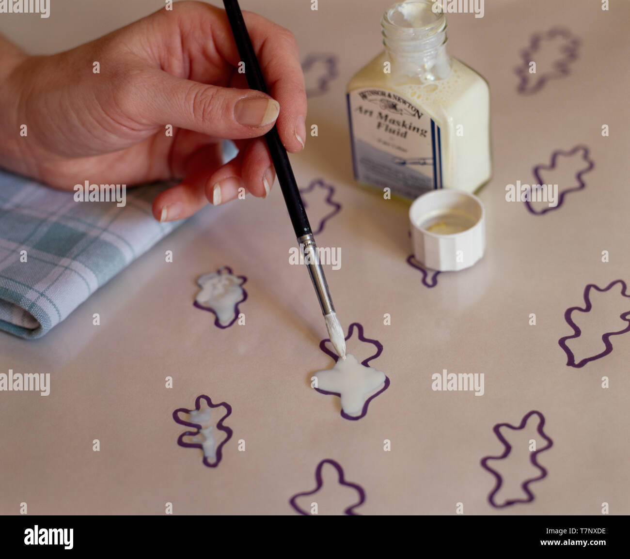 Hand applying art masking fluid to drawing Stock Photo - Alamy