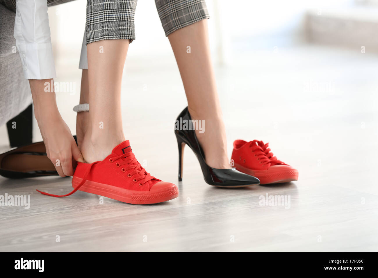 Tired woman changing shoes indoors Stock Photo - Alamy
