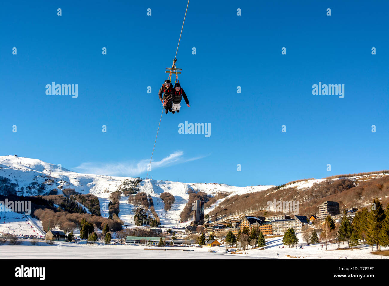 Persons on Zip wire line in Super Besse ski resort,  Regional Nature Park of Volcans d'Auvergne, Puy de Dome, Auvergne, France Stock Photo