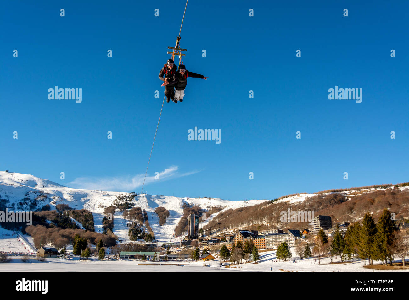 Persons on Zip wire line in Super Besse ski resort,  Regional Nature Park of Volcans d'Auvergne, Puy de Dome, Auvergne, France Stock Photo
