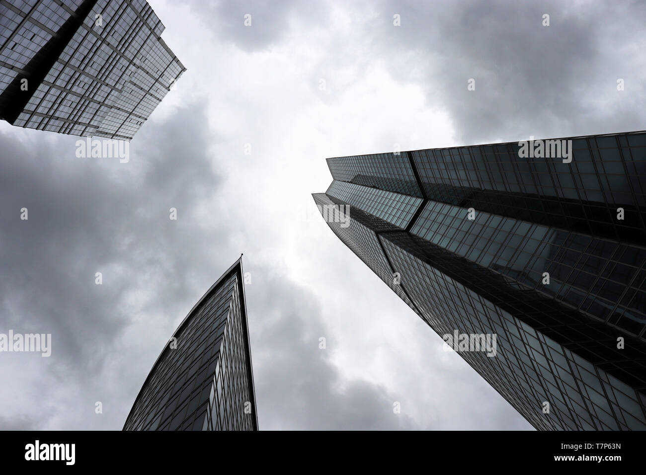 Skyscrapers on stormy cloudy sky background, bottom view. Futuristic city with dramatic sky, modern architecture, urbanization concept Stock Photo