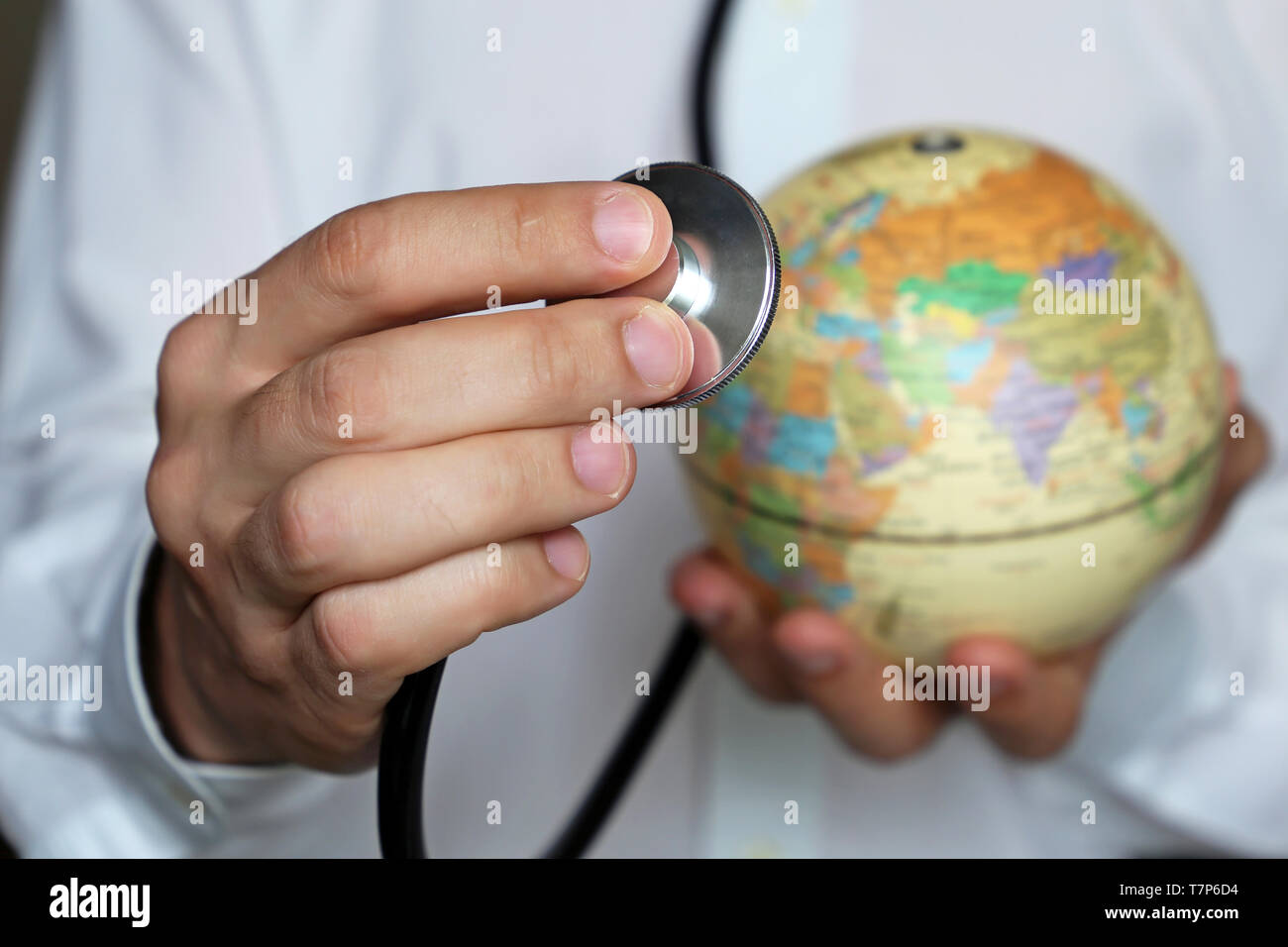 Doctor with stethoscope and globe in his hand. Medical network and health care in Europe and Africa, concept of world medicine, epidemic control Stock Photo