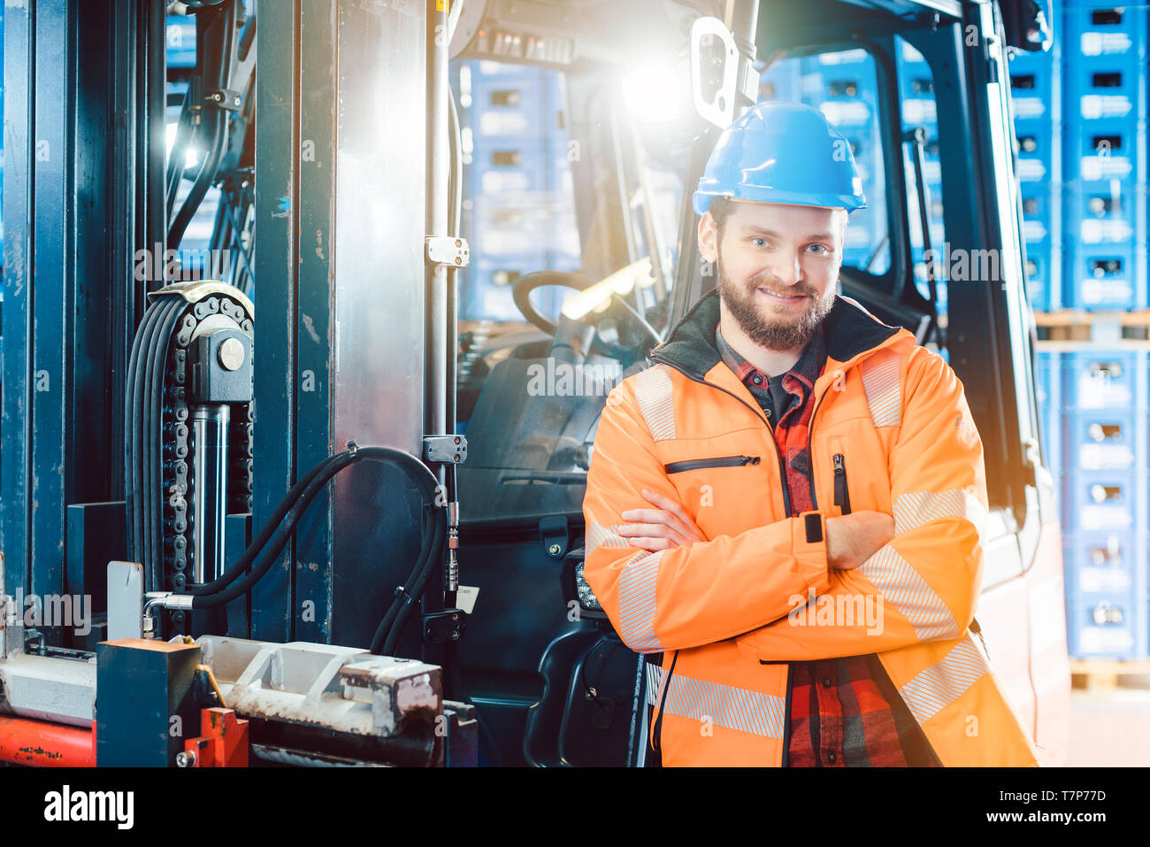 Worker in logistics distribution center with his forklift Stock Photo