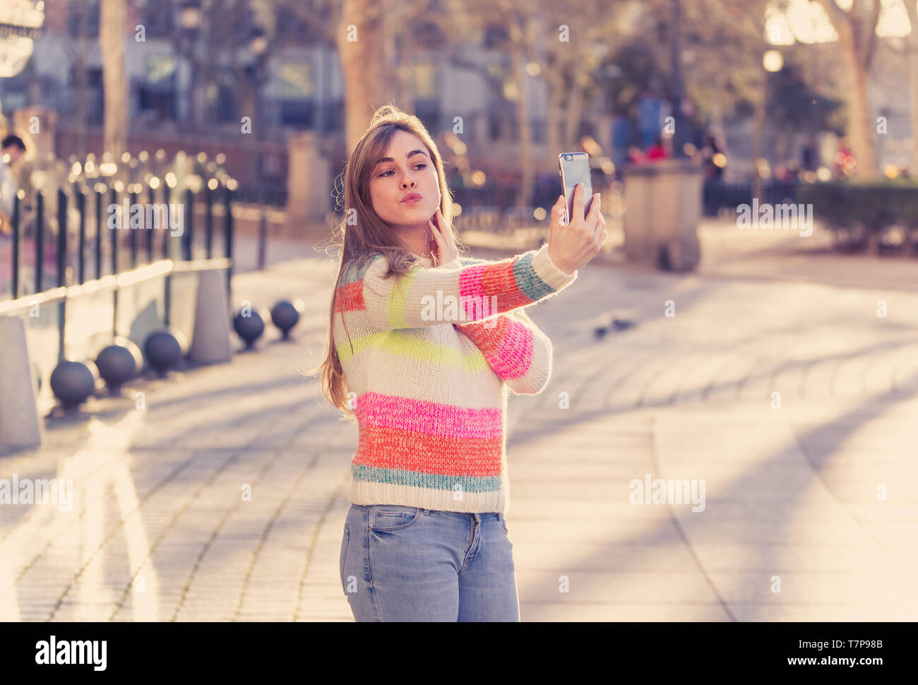 Pretty teenager girl taking selfie happy and excited in the city. Young student woman recording video of herself blogging outdoors In Millennial gener Stock Photo