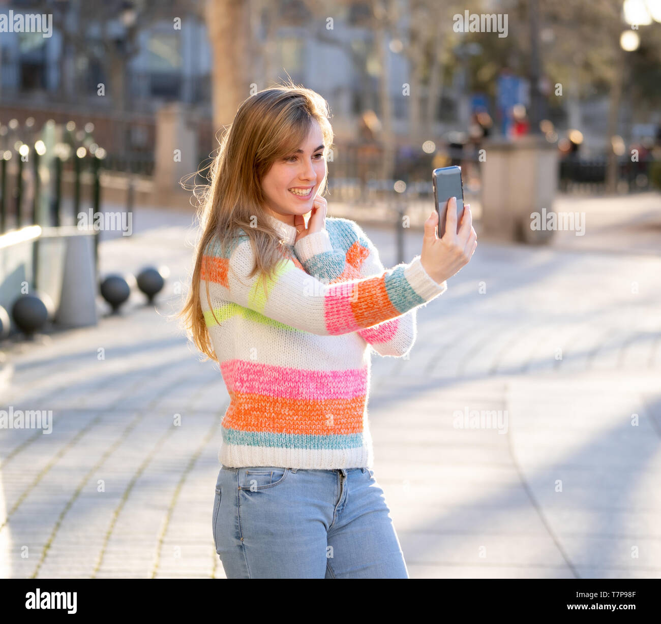 Pretty teenager girl taking selfie happy and excited in the city. Young student woman recording video of herself blogging outdoors In Millennial gener Stock Photo