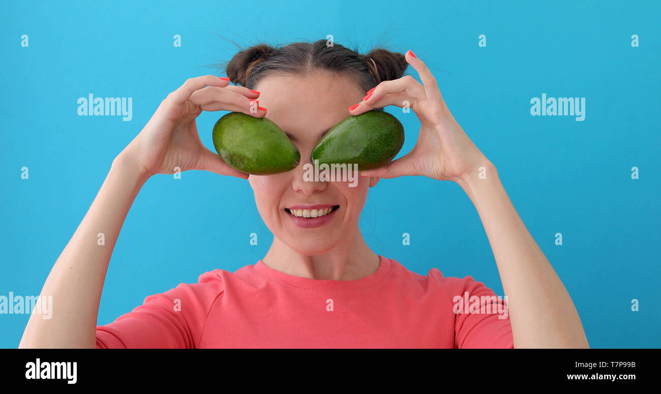 Cheerful Woman Making Avocado Eyes Stock Photo