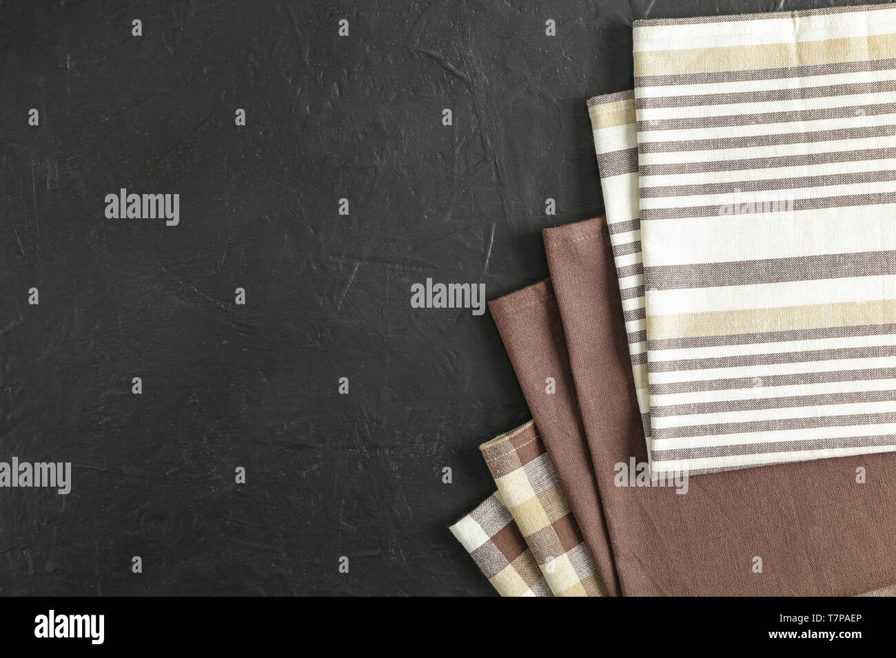 Fabric napkins on black background, space for text Stock Photo