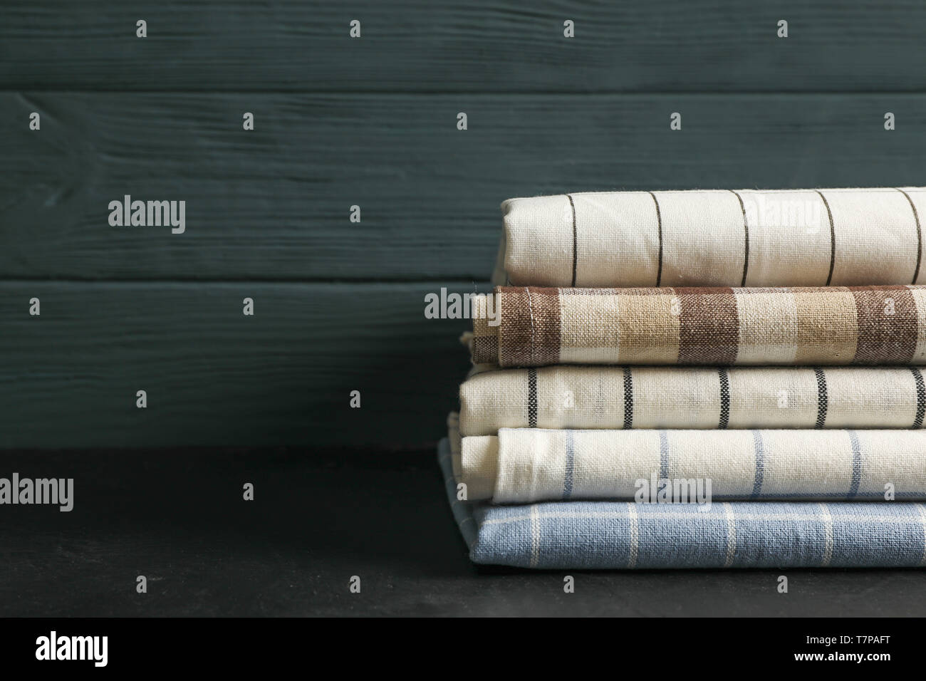 Stack of fabric napkins on black table, space for text Stock Photo