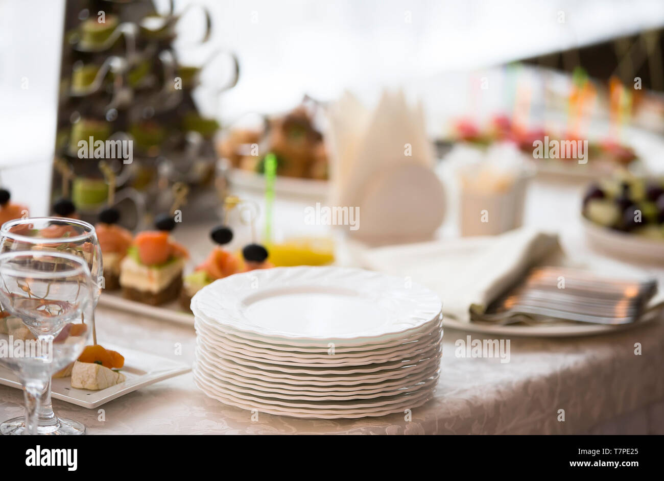 A stack of white plates on the table of the buffet table Stock Photo