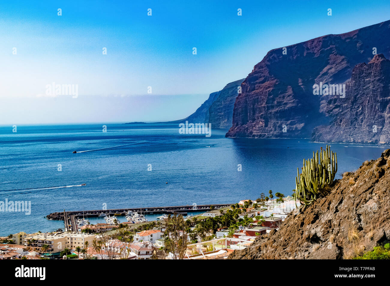 Los Gigantes and the harbour of Puerto de Santiago from a viewpoint. Those imposing rocks are thrown directly into the water. That's amazing. Stock Photo
