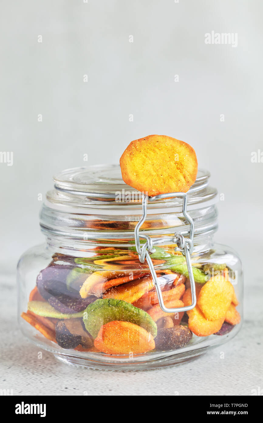 Colourful mix vegetable chips in glass jar, vertical composition Stock Photo