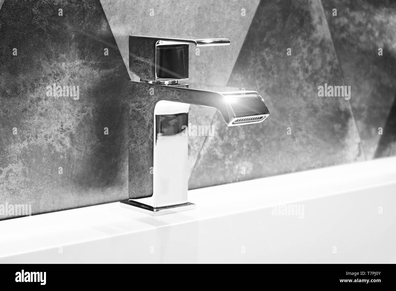 Luxury modern style faucet mixer on a white sink in a beautiful gray  metallic style bathroom Stock Photo